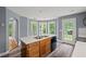 This kitchen island features stainless appliances, wood cabinets, a white countertop, and a door to the backyard at 2333 Old Newnan Rd, Carrollton, GA 30116