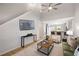 Bright living room featuring a ceiling fan and an open floorplan to the kitchen at 3063 Broadleaf Trl, Fairburn, GA 30213