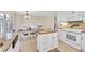 Bright eat-in kitchen with white cabinetry, tile floors, and a view into the living area at 3107 Bunker Hill Cir, Marietta, GA 30062