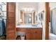 Bathroom with marble countertop, mirror, and wooden cabinets at 5317 Highway 81, Loganville, GA 30052