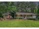 Charming single-story home with a welcoming front porch and a lush green lawn surrounded by mature trees at 5317 Highway 81, Loganville, GA 30052