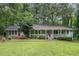 Charming single-story home with a welcoming front porch and a lush green lawn surrounded by mature trees at 5317 Highway 81, Loganville, GA 30052