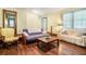Inviting living area showcasing hardwood floors, a futon, and natural light streaming through large windows at 5317 Highway 81, Loganville, GA 30052