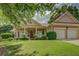 Charming home with a well-manicured lawn and a covered front porch with supporting columns, creating inviting curb appeal at 1065 Chippewa Oak Dr, Dacula, GA 30019