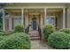 Inviting front porch featuring classic columns, a brick walkway, and lush landscaping leading to a stylish front door at 1065 Chippewa Oak Dr, Dacula, GA 30019