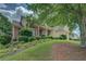 Inviting home with lush green lawn, mature trees, and a well-maintained garden at 1065 Chippewa Oak Dr, Dacula, GA 30019