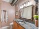 Well-lit bathroom with granite countertop, decorative mirror, and modern fixtures at 1661 La France Ne St # 222, Atlanta, GA 30307