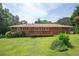 Brick house featuring a wooden deck with a large, well-maintained lawn and landscaping at 3332 Clay Rd, Austell, GA 30106
