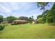 Large backyard with a brick house, wooden deck, green grass, and a storage building at 3332 Clay Rd, Austell, GA 30106
