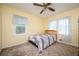 Cozy bedroom with a ceiling fan, two windows, carpet, and a comfortable-looking bed at 3332 Clay Rd, Austell, GA 30106