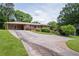 Long driveway leading to a single-story brick home with carport and mature landscaping at 3332 Clay Rd, Austell, GA 30106