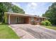 Single-story brick home with a carport, showcasing mature landscaping and an expansive driveway at 3332 Clay Rd, Austell, GA 30106