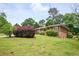 View of a charming one-story brick home with mature landscaping and a spacious lawn at 3332 Clay Rd, Austell, GA 30106
