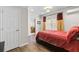 Bedroom with wood floors and bed with red striped bedding and an adjacent door at 7335 Treyland Ct, Cumming, GA 30041