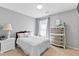 Cozy bedroom featuring carpet, gray walls, a bed and matching white nightstand at 7335 Treyland Ct, Cumming, GA 30041