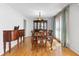 Formal dining room featuring hardwood floors, elegant furnishings, and ample natural light through draped windows at 7335 Treyland Ct, Cumming, GA 30041