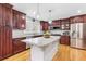 Well-lit kitchen with granite countertops, stainless steel appliances, cherry cabinets, and wooden floors at 7335 Treyland Ct, Cumming, GA 30041
