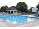 Inviting community pool surrounded by ample lounge chairs, gazebos, and lush greenery for ultimate relaxation at 7335 Treyland Ct, Cumming, GA 30041