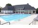 Community pool with blue water, surrounded by lounge chairs and a clubhouse, creating a relaxing atmosphere at 7335 Treyland Ct, Cumming, GA 30041