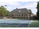 Large clubhouse featuring tennis court in foreground and inviting facade, ideal for active community living at 7335 Treyland Ct, Cumming, GA 30041