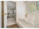 Bright bathroom featuring a large soaking tub with gold fixtures and shuttered windows, open to the bedroom at 110 Windsor Chase Dr, Lawrenceville, GA 30043