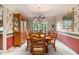 Formal dining room with a wooden table and chairs, vintage hutch, and floral wallpaper at 110 Windsor Chase Dr, Lawrenceville, GA 30043