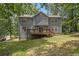 The backyard of the gray two-story house features a deck and a well-maintained lawn at 110 Windsor Chase Dr, Lawrenceville, GA 30043