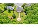Aerial view of the home showing the backyard with a firepit, playground, and lush green grass at 5388 Silver Springs Dr, Sugar Hill, GA 30518