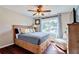 Comfortable bedroom with a queen size bed, wood floors, ceiling fan, and natural light at 5388 Silver Springs Dr, Sugar Hill, GA 30518