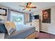 Comfortable bedroom with a queen size bed, wood floors, ceiling fan, and natural light at 5388 Silver Springs Dr, Sugar Hill, GA 30518