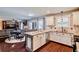 Open concept kitchen with breakfast bar and seamlessly connected to the dining and living areas at 5388 Silver Springs Dr, Sugar Hill, GA 30518