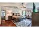 Large primary bedroom with hardwood floors, ceiling fan and sitting area at 5388 Silver Springs Dr, Sugar Hill, GA 30518
