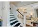 Staircase leading to a cozy living room with comfortable seating and natural light at 5388 Silver Springs Dr, Sugar Hill, GA 30518