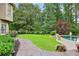 Well-manicured backyard with stone walkway leading to a pool and wooded area at 219 Deer Park Trl, Canton, GA 30114