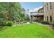 Beautiful backyard featuring a lush lawn, stone patio, in-ground pool, and outdoor fireplace at 219 Deer Park Trl, Canton, GA 30114