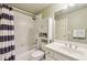 Bathroom with vanity and mirror adjacent to a bathtub and shower with striped curtain at 219 Deer Park Trl, Canton, GA 30114
