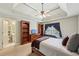 Bedroom with ceiling fan, desk near a window, and shelving on each side of a dresser at 219 Deer Park Trl, Canton, GA 30114