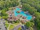 Aerial view of a large community pool and clubhouse surrounded by lush greenery and amenities at 219 Deer Park Trl, Canton, GA 30114