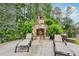 Outdoor stone fireplace with lounge chairs, perfect for cozy evenings in the backyard at 219 Deer Park Trl, Canton, GA 30114