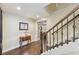 Hallway with wooden staircase, classic design elements, and a view of a well-lit room through glass doors at 219 Deer Park Trl, Canton, GA 30114