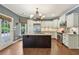 Kitchen with a central island, stainless steel appliances, and white cabinets, perfect for cooking and entertaining at 219 Deer Park Trl, Canton, GA 30114