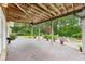 Expansive covered patio featuring a stone floor and offering views of the pool and landscaped backyard at 219 Deer Park Trl, Canton, GA 30114