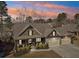 Aerial view of the home with a three-car garage, inviting porch, and well-manicured front yard at sunset at 266 Hanover Dr, Villa Rica, GA 30180