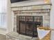 Stone fireplace with mantel, hearth, and metal screen, complemented by decorative basket on stone platform at 266 Hanover Dr, Villa Rica, GA 30180