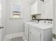 Well-lit laundry room featuring washer, dryer, and built-in storage shelves at 266 Hanover Dr, Villa Rica, GA 30180
