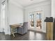 Bright home office with hardwood floors, desk, comfortable chair, and doors to screened porch at 266 Hanover Dr, Villa Rica, GA 30180