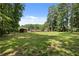 Expansive backyard with mature trees and a charming brick house, offering a serene outdoor setting at 3082 Briarleaf Dr, Decatur, GA 30034