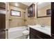 Bathroom featuring a tub-shower combination, tiled walls, and dark wood cabinets at 3082 Briarleaf Dr, Decatur, GA 30034