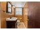 Half bathroom with a dark vanity, tiled floor, and window, offering simple functionality at 3082 Briarleaf Dr, Decatur, GA 30034