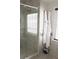 Modern shower with glass doors, tiled walls, and decorative robes hanging near a window at 1062 Lena Nw St, Atlanta, GA 30314